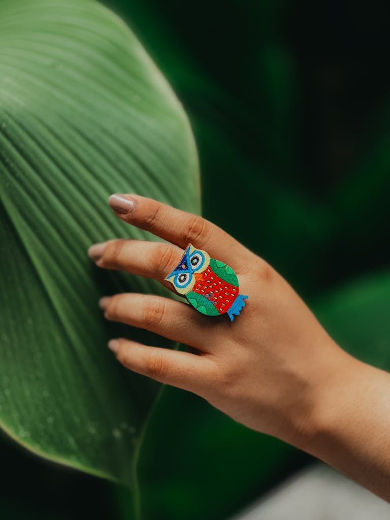 bright colourful resin owl ring on a girls finger - highlighting a bold jewelry niche