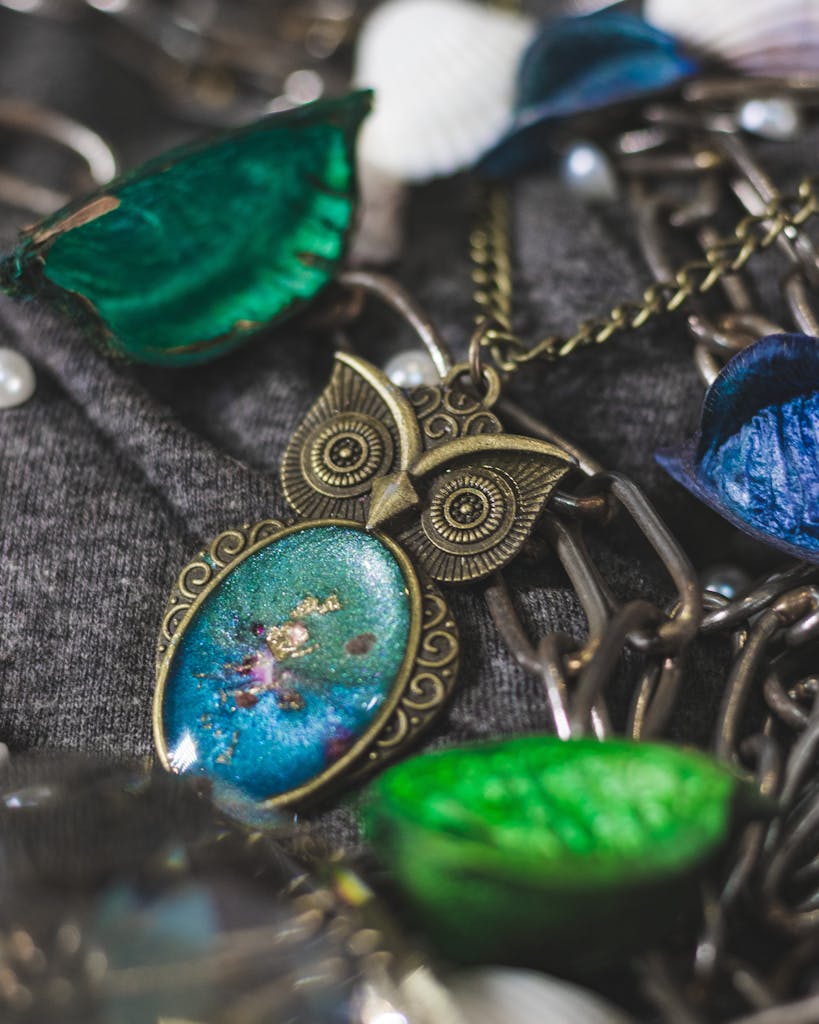 Close-up of a beautifully crafted owl pendant necklace with intricate details and vibrant colors.