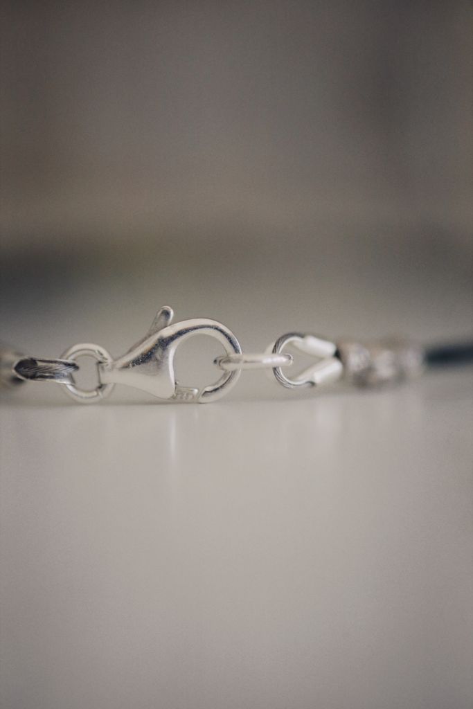 Detailed close-up view of a silver chain link clasp on a blurred background.